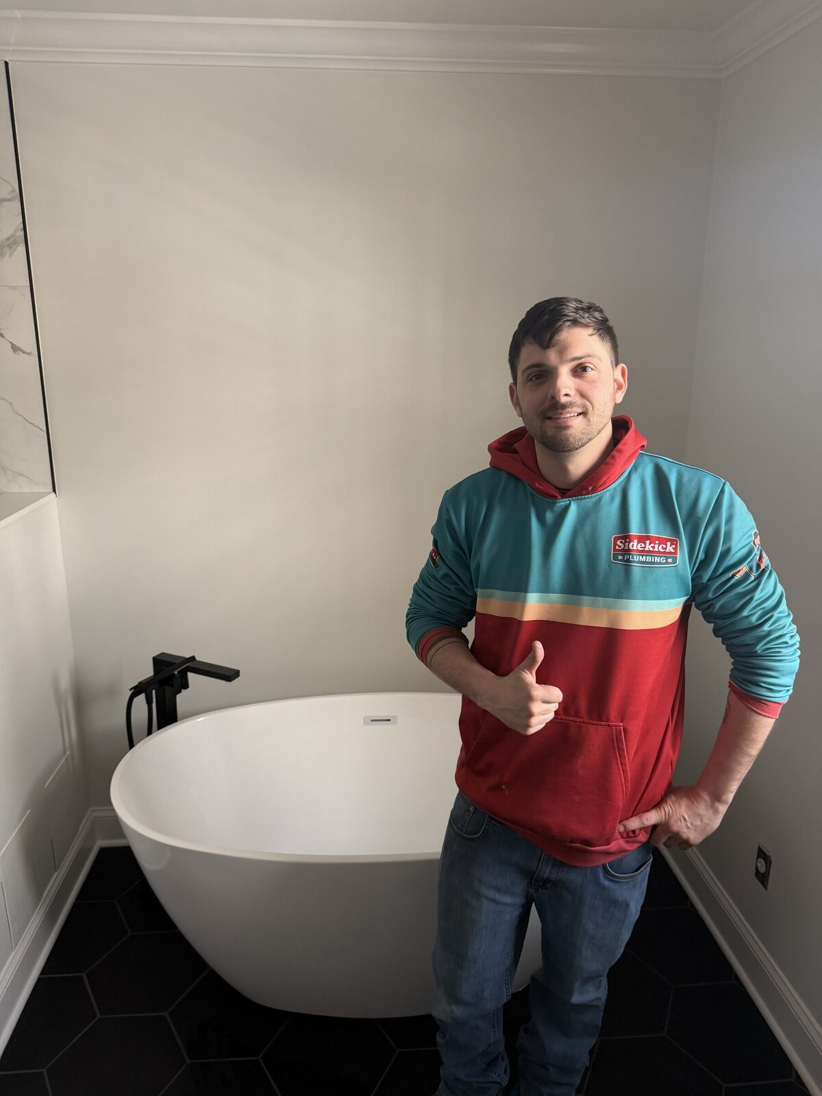 Jimmy, Sidekick Plumbing's licensed master plumber, in a finished bathroom installation